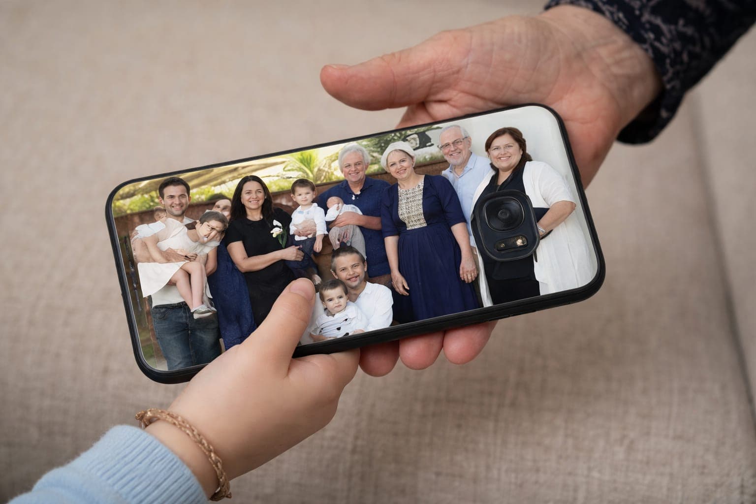 ילד נותן לסבתא טלפון עם תמונה משפחתית על הכיסוי.